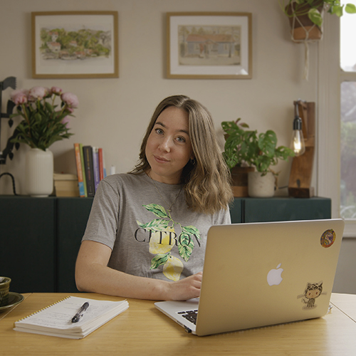 photo of Kajsa (me) sitting at a desk with my macbook